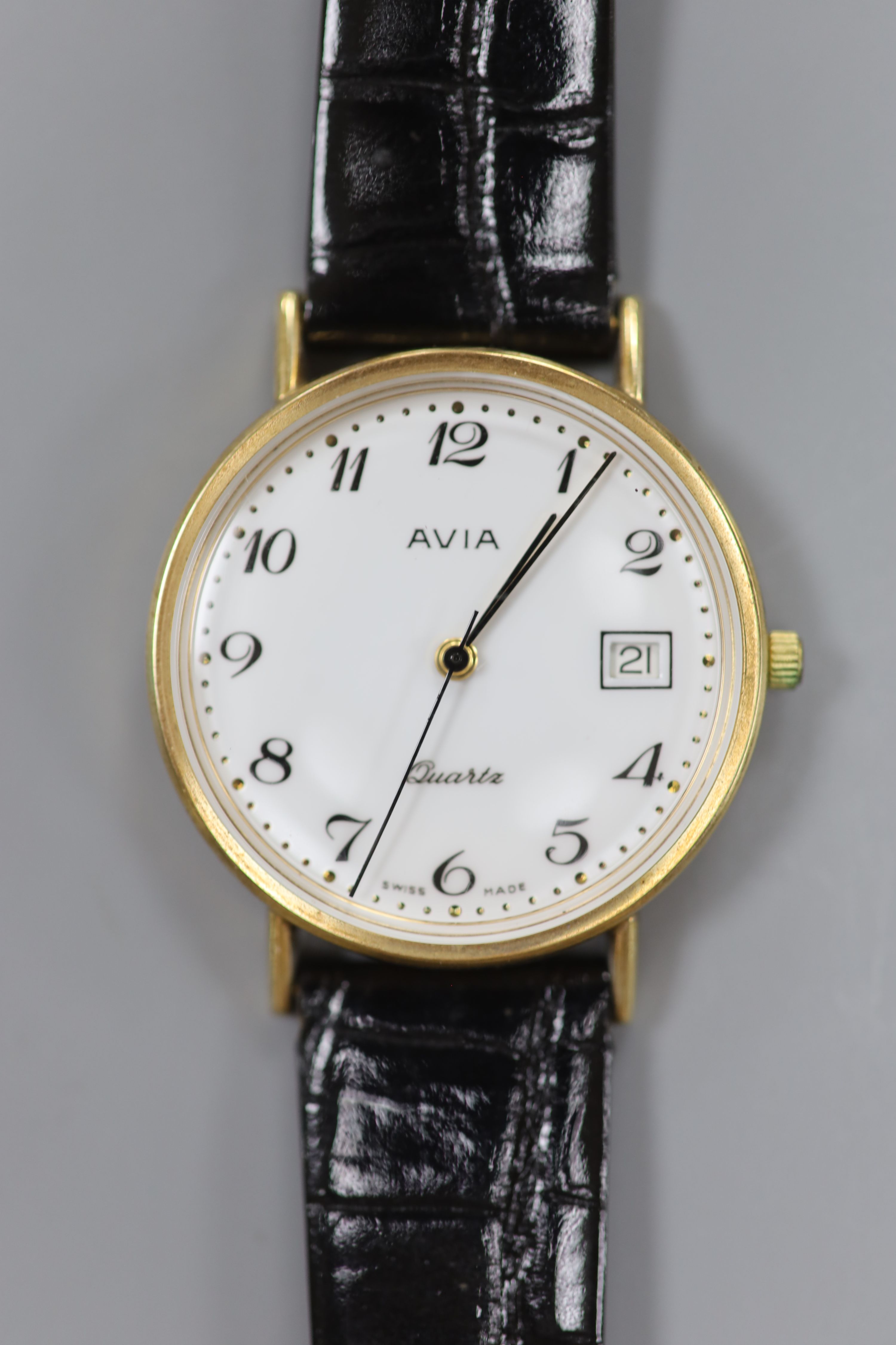 A gentleman's modern 9ct gold Avia quartz wrist watch, on associated strap, cased diameter 33mm, gross weight 22.1 grams.